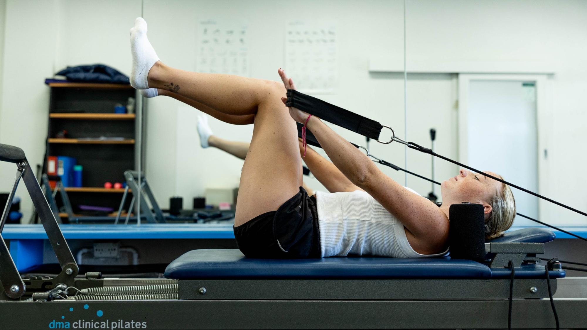 A young woman taking part in a Reformer Pilates class held by SSPC in their Pilates Studio in Melbourne.